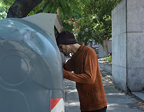 Driver standing in front of a blue waste truck